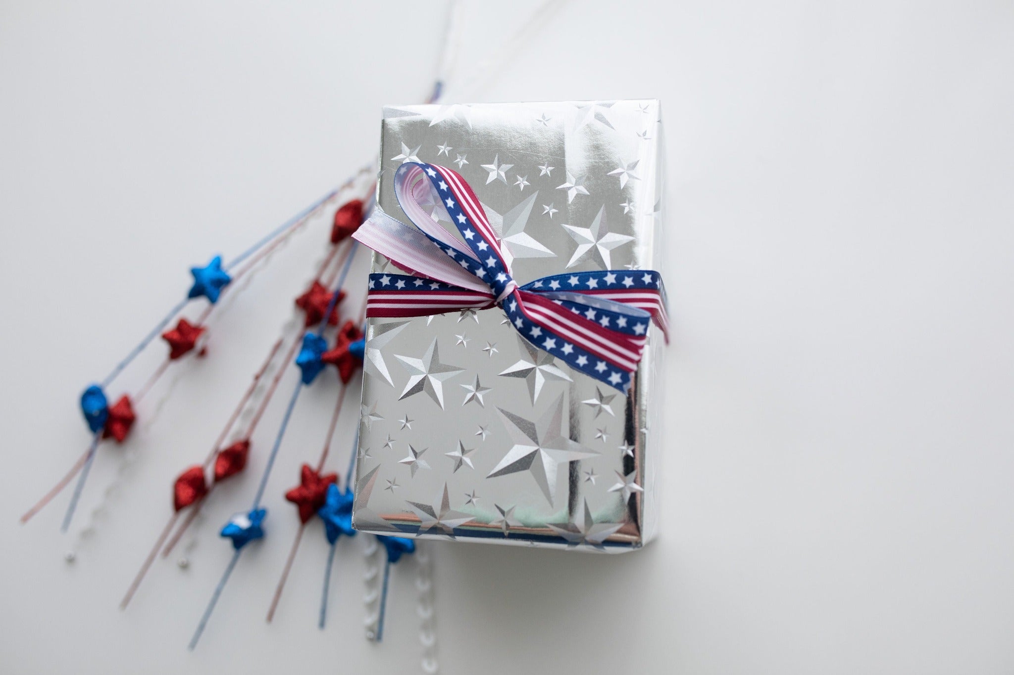 a wrapped box in silver foil stars and stars and stripes ribbon