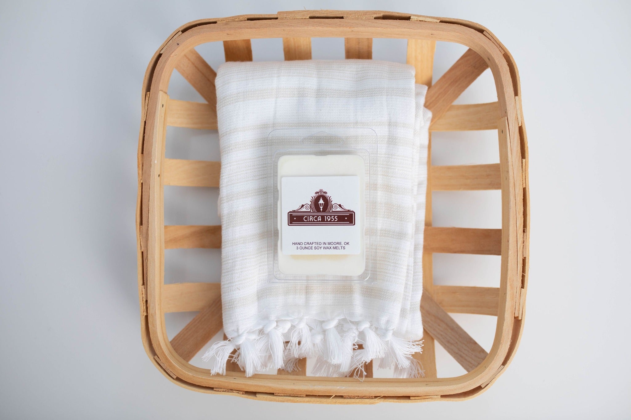 A plastic, six-cavity clamshell melt in a wood basket with a linen towel.