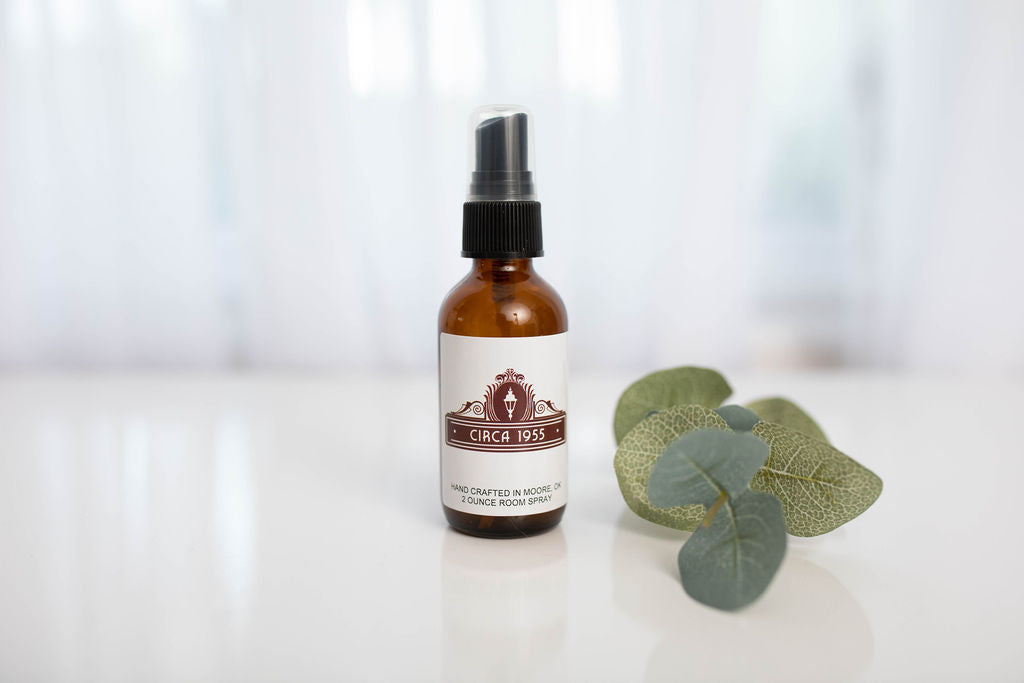 an amber glass bottle with a sprig of eucalyptus next to it.