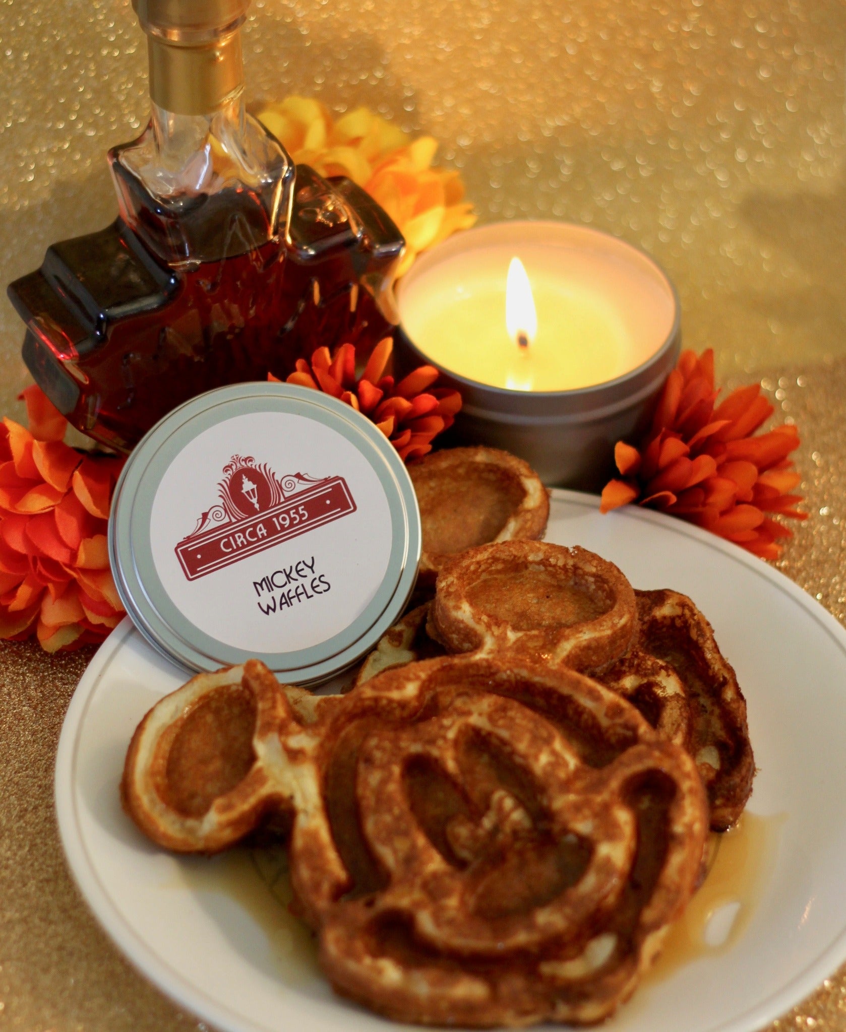 a metal candle tin with mickey shaped waffles and syrup