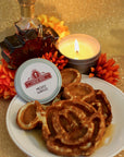 a metal candle tin with mickey shaped waffles and syrup